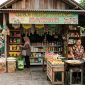 Seorang pedagang melayani pembeli di warung sembako sekaligus menjual gorengan di teras rumah