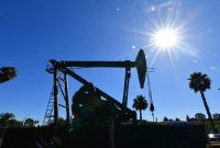 Pompa minyak beroperasi di tengah cuaca cerah, mencerminkan dinamika industri energi global di tengah fluktuasi harga minyak dunia.(Foto: AFP)