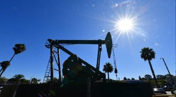 Pompa minyak beroperasi di tengah cuaca cerah, mencerminkan dinamika industri energi global di tengah fluktuasi harga minyak dunia.(Foto: AFP)