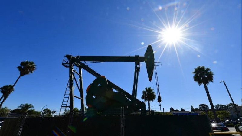 Pompa minyak beroperasi di tengah cuaca cerah, mencerminkan dinamika industri energi global di tengah fluktuasi harga minyak dunia.(Foto: AFP)