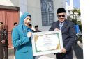 Wali Kota Alfin menyerahkan penghargaan usai upacara Harkitnas ke-118 di Sungai Penuh.