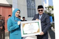 Wali Kota Alfin menyerahkan penghargaan usai upacara Harkitnas ke-118 di Sungai Penuh.