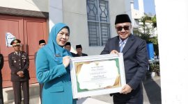 Wali Kota Alfin menyerahkan penghargaan usai upacara Harkitnas ke-118 di Sungai Penuh.