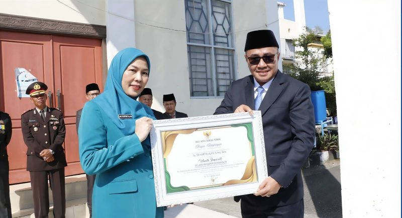 Wali Kota Alfin menyerahkan penghargaan usai upacara Harkitnas ke-118 di Sungai Penuh.