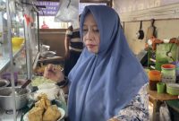 Bude Puji melayani pembeli sekaligus membagikan nasi gratis kepada penumpang dan pedagang di Pelabuhan Bakauheni.