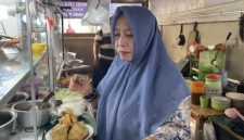 Bude Puji melayani pembeli sekaligus membagikan nasi gratis kepada penumpang dan pedagang di Pelabuhan Bakauheni.