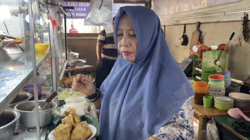 Bude Puji melayani pembeli sekaligus membagikan nasi gratis kepada penumpang dan pedagang di Pelabuhan Bakauheni.