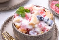 Salad buah creamy dengan aneka buah segar dan keju parut.