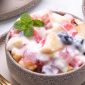 Salad buah creamy dengan aneka buah segar dan keju parut.