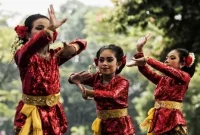 Sejumlah penari cilik menampilkan tarian tradisional Sunda dengan gerakan anggun dalam balutan busana merah berkilau dan kain batik khas di ruang terbuka. (Foto: Freepik)