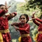 Sejumlah penari cilik menampilkan tarian tradisional Sunda dengan gerakan anggun dalam balutan busana merah berkilau dan kain batik khas di ruang terbuka. (Foto: Freepik)