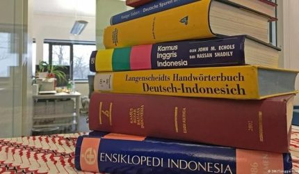 Ilustrasi kamus terbuka yang menampilkan halaman kata-kata bahasa.
