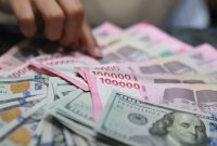 Ilustrasi rupiah dan dolar AS yang mencerminkan tekanan nilai tukar terhadap perekonomian dan industri nasional.(Fhoto : Bloomberg Technoz/ Andrean Kristianto)