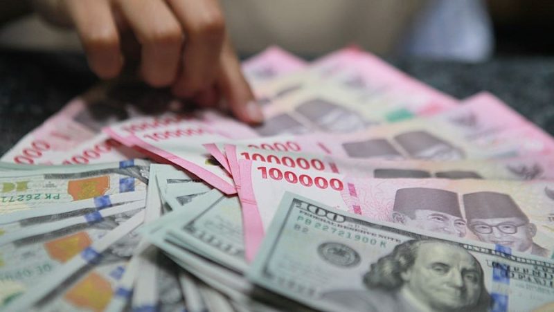 Ilustrasi rupiah dan dolar AS yang mencerminkan tekanan nilai tukar terhadap perekonomian dan industri nasional.(Fhoto : Bloomberg Technoz/ Andrean Kristianto)