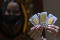 Foto: Karyawati menunjukkan emas PT Aneka Tambang Tbk. (Antam) di salah satu gallery penjualan emas di Jakarta, Kamis (4/5). (CNBC Indonesia/Muhammad Sabki)