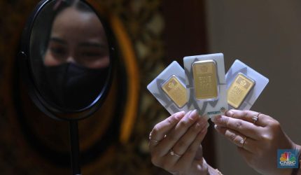 Karyawati menunjukkan emas batangan PT Aneka Tambang Tbk (Antam) di galeri penjualan emas di Jakarta pada Kamis (4/5).