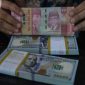 Layar menampilkan pergerakan nilai tukar rupiah yang melemah terhadap dolar AS pada perdagangan terbaru