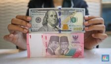Petugas menghitung uang rupiah dan dolar AS, mencerminkan pelemahan nilai tukar rupiah terhadap dolar AS.(fhoto CNBC Indonesia/Faisal Rahman)