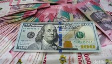 Lembaran uang dolar Amerika Serikat pecahan 100 dolar berada di atas tumpukan uang rupiah, menggambarkan penguatan dolar AS terhadap rupiah di pasar keuangan.(Ilustrasi/Foto: Gilang Faturahman/detikFoto)