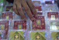 Petugas melayani pembeli dalam transaksi jual beli emas Antam di butik logam mulia.