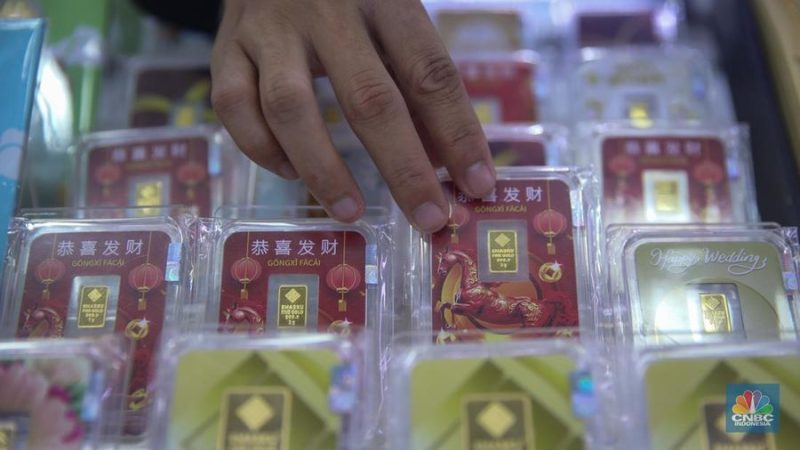 Petugas melayani pembeli dalam transaksi jual beli emas Antam di butik logam mulia.