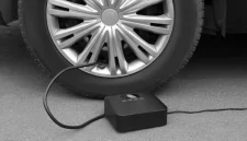 Pompa angin elektrik portable mengisi ban mobil di jalan(NewAfrica/Depositphotos)
