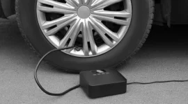 Pompa angin elektrik portable mengisi ban mobil di jalan(NewAfrica/Depositphotos)