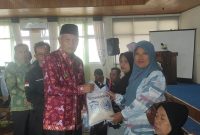 Wakil Wali Kota Sungai Penuh menyerahkan bantuan kepada masyarakat pada Bakti Sosial Terintegrasi Kemensos RI.