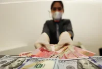 Pergerakan nilai tukar rupiah yang menguat tipis terhadap dolar AS dipengaruhi sentimen global menjelang pengumuman hasil rapat FOMC. (Foto : Liputan6.com/Johan Tallo)