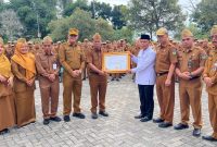 Sekda Alpian menyerahkan penghargaan kepada KUA Hamparan Rawang berprestasi nasional.