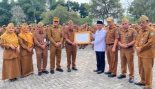 Sekda Alpian menyerahkan penghargaan kepada KUA Hamparan Rawang berprestasi nasional.