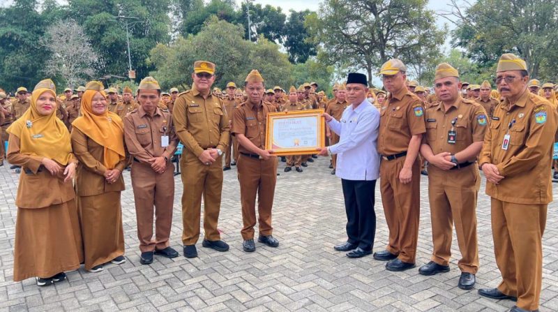 Sekda Alpian menyerahkan penghargaan kepada KUA Hamparan Rawang berprestasi nasional.