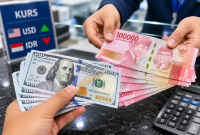 Ilustrasi Petugas menunjukkan uang rupiah saat transaksi penukaran dengan dolar AS di counter bank.