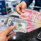 Ilustrasi Petugas menunjukkan uang rupiah saat transaksi penukaran dengan dolar AS di counter bank.
