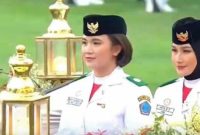Nindya Eltsani Fawwaz membawa bendera pusaka dalam Kirab HUT RI ke-81.