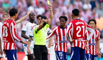 Wasit Miguel Angel Ortiz Arias memberikan kartu kuning dalam laga Atletico Madrid vs Real Madrid.