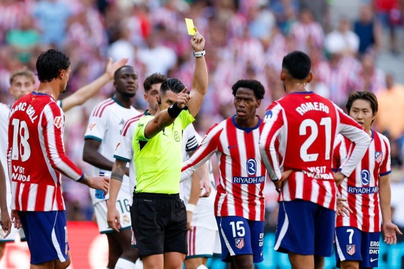 Wasit Miguel Angel Ortiz Arias mengeluarkan kartu kuning dalam laga Atletico Madrid vs Real Madrid di Metropolitano, Madrid. (AFP/Oscar del Pozo)