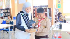 Bunda Literasi Sri Kartini Alfin mendampingi murid SD dalam kegiatan literasi di perpustakaan.