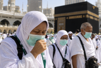 Jemaah haji Indonesia mengenakan masker saat beribadah di tengah kerumunan di Masjidil Haram, Makkah.