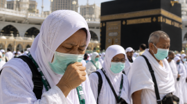 Jemaah haji Indonesia mengenakan masker saat beribadah di tengah kerumunan di Masjidil Haram, Makkah.