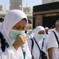 Jemaah haji Indonesia mengenakan masker saat beribadah di tengah kerumunan di Masjidil Haram, Makkah.