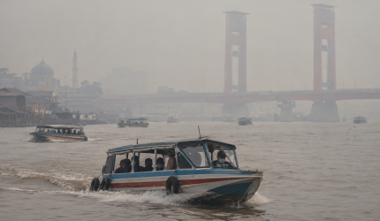Kabut asap menyelimuti Sungai Musi, Palembang, sementara speedboat tetap melayani penumpang.