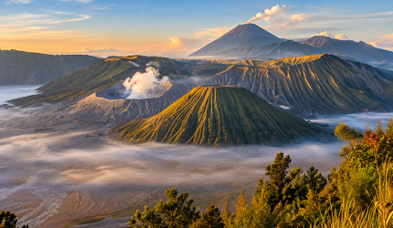 Gunung Bromo dengan kawah berasap dan kabut pagi.
