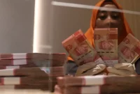 Rupiah melemah terhadap dolar AS pada perdagangan Selasa (13/10/2026) seiring meningkatnya tekanan geopolitik dan kenaikan harga minyak dunia.(Foto : Liputan6.com/Angga Yuniar)