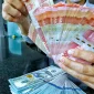 Rupiah melemah terhadap dolar AS di tengah tekanan pasar domestik dan ketegangan geopolitik global.(Foto : Liputan6.com/Angga Yuniar)