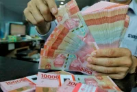 Rupiah melemah ke Rp18.035 per dolar AS seiring tekanan pasar global dan kenaikan harga minyak.(Foto : Liputan6.com/Angga Yuniar)