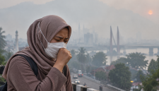 Ilustrasi warga menggunakan masker di tengah kabut asap akibat karhutla.( Foto AI Inbrita)