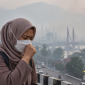 Ilustrasi warga menggunakan masker di tengah kabut asap akibat karhutla.( Foto AI Inbrita)