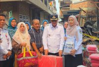 Wali Kota Sungai Penuh Alfin menyerahkan bantuan kepada warga terdampak kebakaran di Desa Pasar Baru Sungai Penuh, Rabu (7/10/2026).(Foto : Prokopim Kota Sungai Penuh)