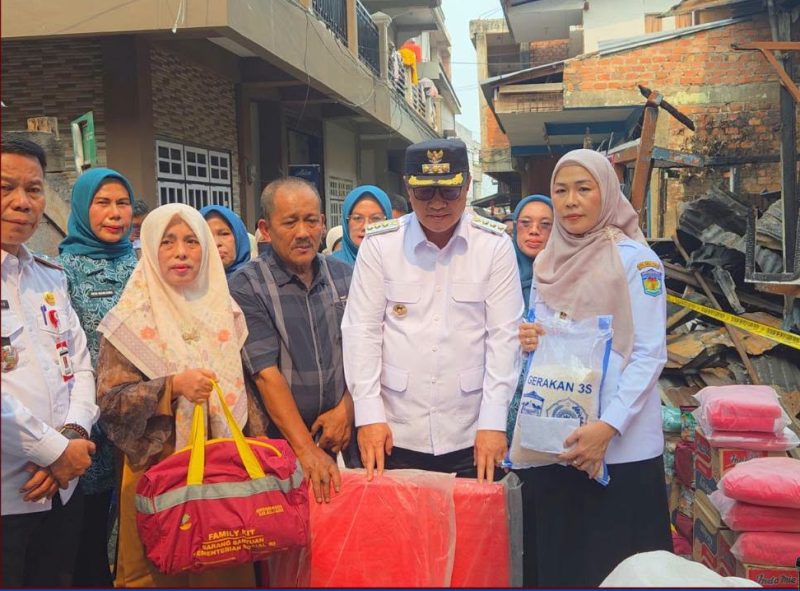 Wali Kota Sungai Penuh Alfin menyerahkan bantuan kepada warga terdampak kebakaran di Desa Pasar Baru Sungai Penuh, Rabu (7/10/2026).(Foto : Prokopim Kota Sungai Penuh)